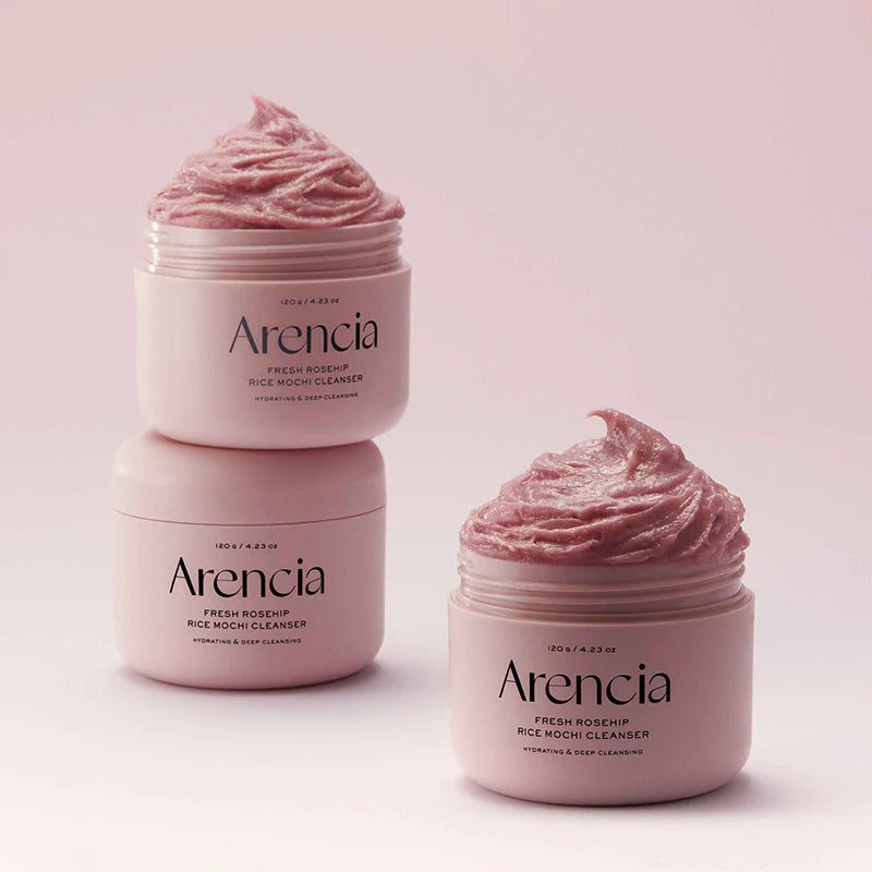 Three jars of Arencia Fresh Rosehip Rice Nook Cleanser on a light pink background